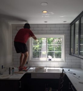 Man working on kitchen backsplash