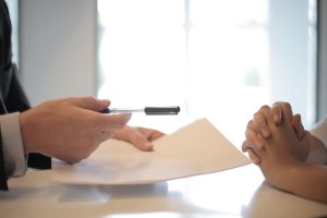 Man handing women a pen